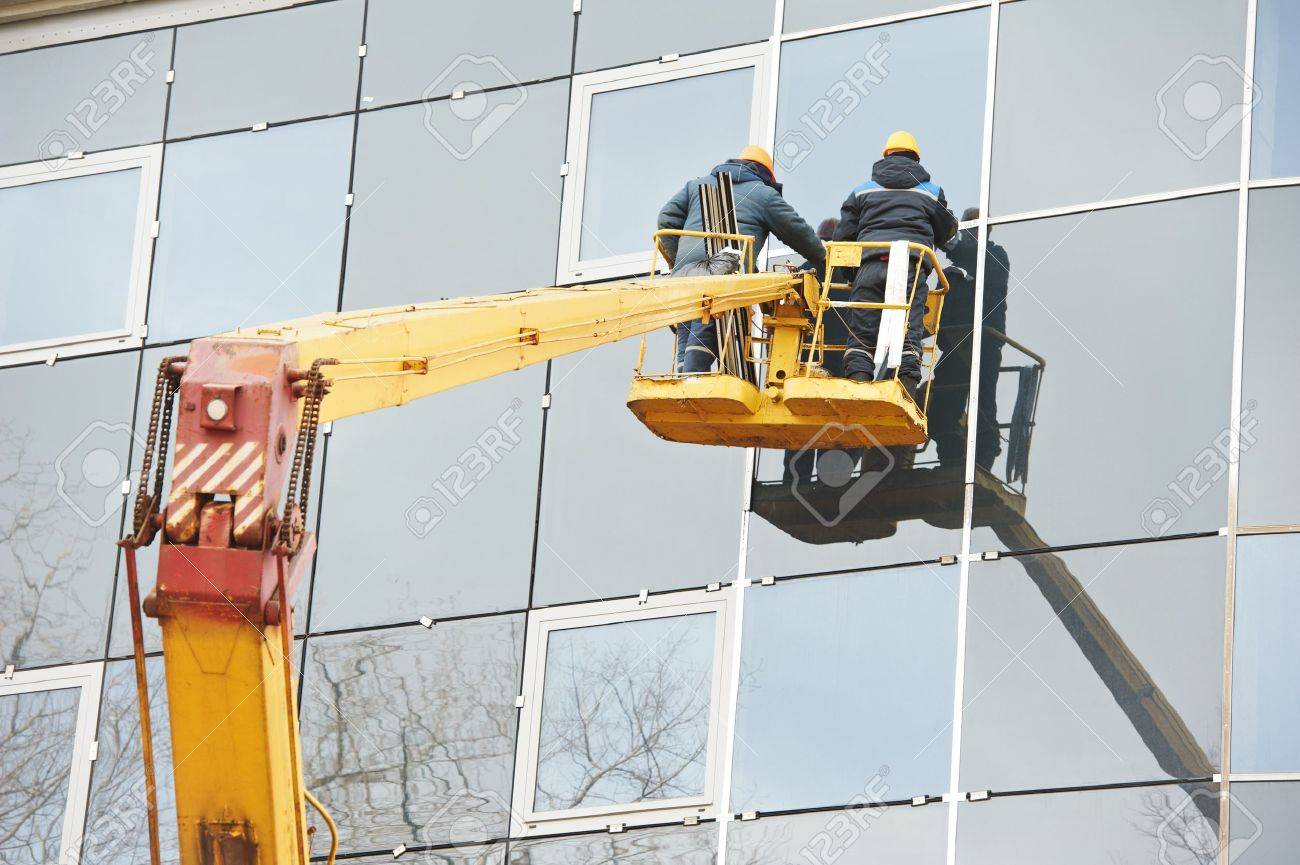 18872337-workers-installing-glass-window-on-building.jpg